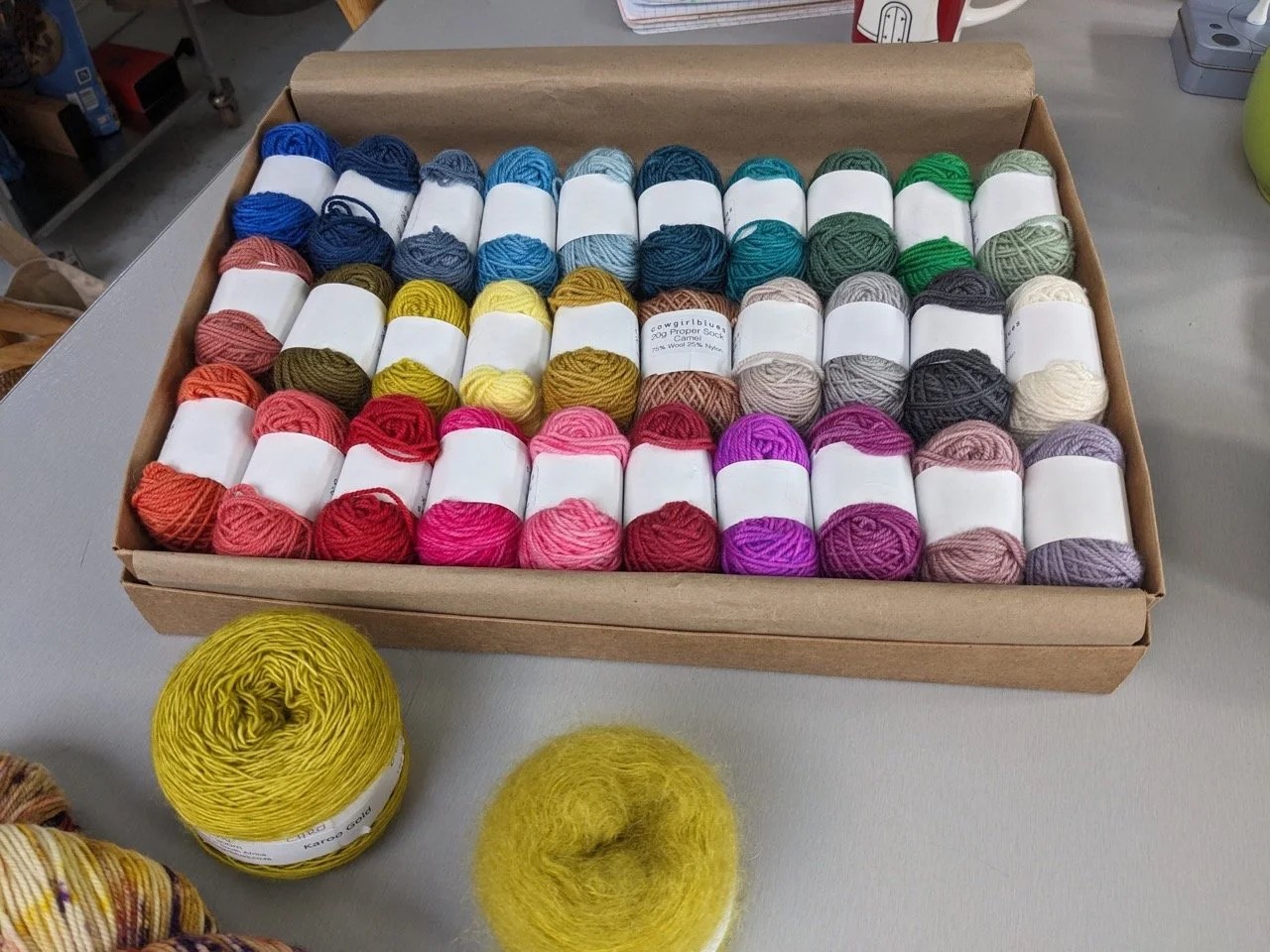  Le nuancier des faux-unis Cowgirl Blues… J’ai choisi un rose foncé, rangée du bas, le 5e en partant de la droite. Je vais recevoir le mohair et le fil à chaussettes afin de contenter ma lubie de tricoter des chaussettes assorties à mes pulls. 